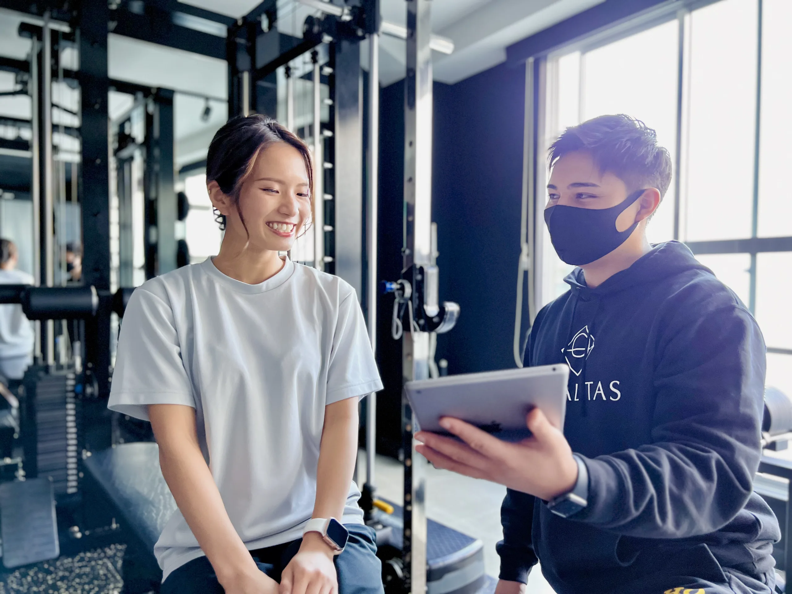 IMG_2970のコピー | QUALITAS神楽坂店【トレーニング×痩身エステ】 神楽坂・飯田橋のパーソナルジム QUALITAS神楽坂店で男性トレーナーにカウンセリングを受けている女性