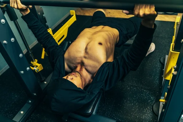ベンチプレスで筋トレする男性